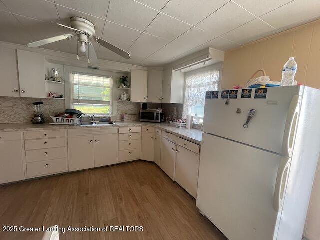 4022 Stabler St, Lansing, MI 48910 - kitchen with freestanding refrigerator, open shelves, stainless steel microwave, and plenty of natural light