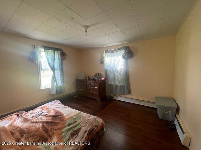 4022 Stabler St, Lansing, MI 48910 - bedroom with a baseboard heating unit, multiple windows, and wood finished floors