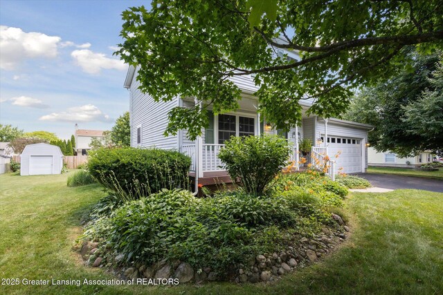 202 Kerry St, Eaton Rapids, MI 48827 - view of property hidden behind natural elements with driveway, a garage, and a front yard