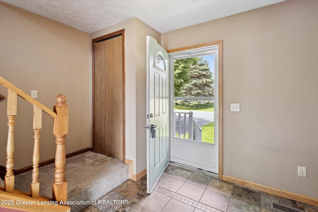202 Kerry St, Eaton Rapids, MI 48827 - foyer entrance featuring healthy amount of natural light, stairs, and a textured ceiling