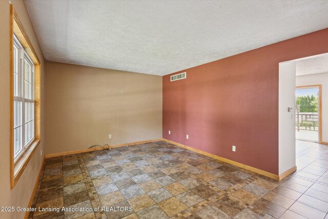 202 Kerry St, Eaton Rapids, MI 48827 - spare room featuring a textured ceiling and stone finish flooring