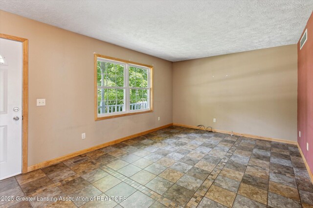 202 Kerry St, Eaton Rapids, MI 48827 - empty room featuring a textured ceiling and stone finish flooring