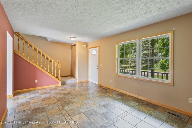 202 Kerry St, Eaton Rapids, MI 48827 - entryway with stairs, a textured ceiling, and stone finish flooring