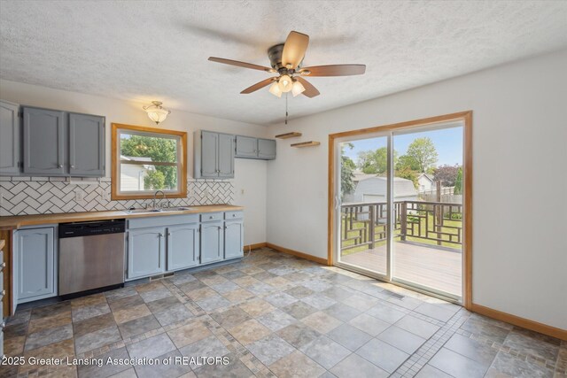 202 Kerry St, Eaton Rapids, MI 48827 - kitchen featuring dishwasher, butcher block countertops, tasteful backsplash, healthy amount of natural light, and a textured ceiling