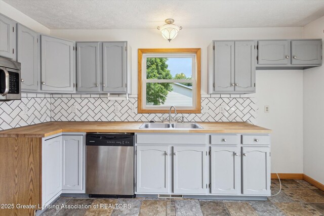 202 Kerry St, Eaton Rapids, MI 48827 - kitchen featuring stainless steel appliances, wooden counters, tasteful backsplash, stone finish floors, and gray cabinets