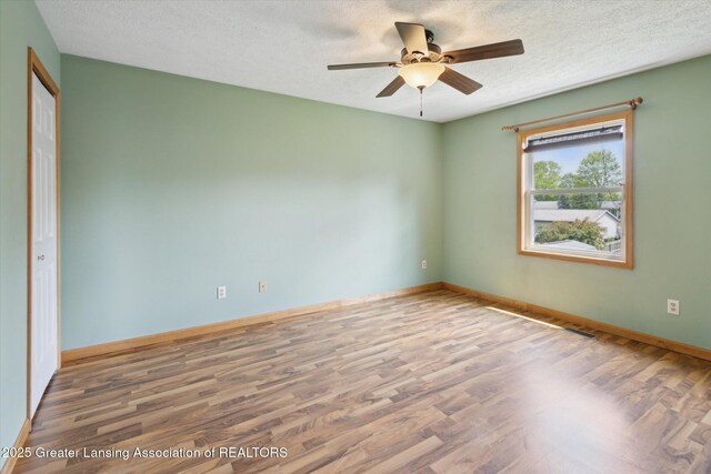 202 Kerry St, Eaton Rapids, MI 48827 - unfurnished room with wood finished floors, a ceiling fan, and a textured ceiling