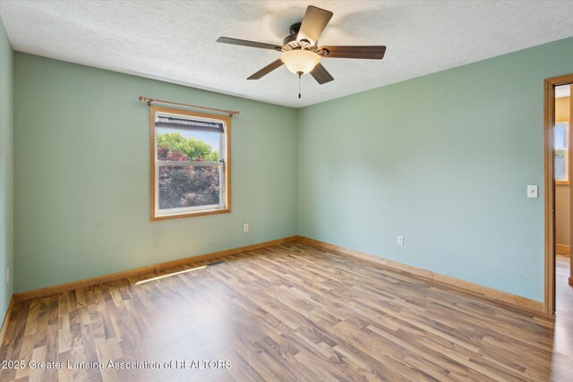202 Kerry St, Eaton Rapids, MI 48827 - unfurnished room featuring wood finished floors, a textured ceiling, and ceiling fan