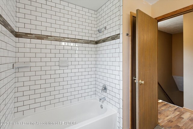 202 Kerry St, Eaton Rapids, MI 48827 - bathroom with washtub / shower combination and wood finished floors