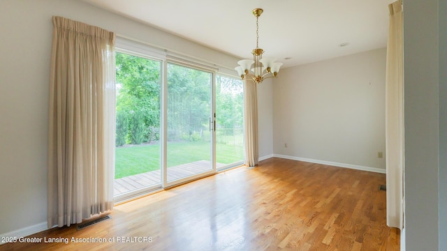 1965 Rutgers Cir, East Lansing, MI 48823 - empty room featuring a chandelier and wood finished floors