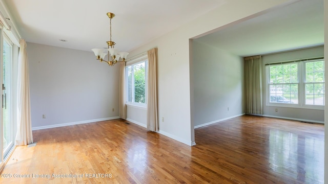 1965 Rutgers Cir, East Lansing, MI 48823 - spare room with a chandelier and light wood-style floors