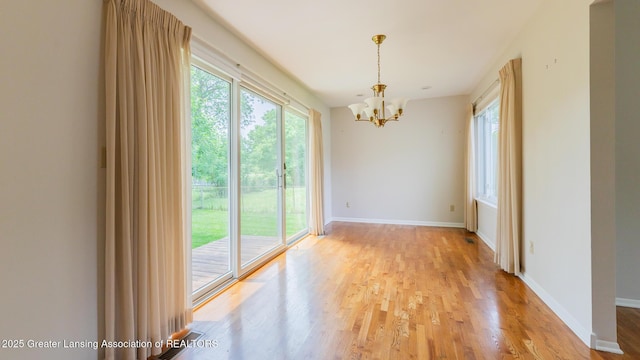 1965 Rutgers Cir, East Lansing, MI 48823 - spare room with a chandelier and light wood-style flooring