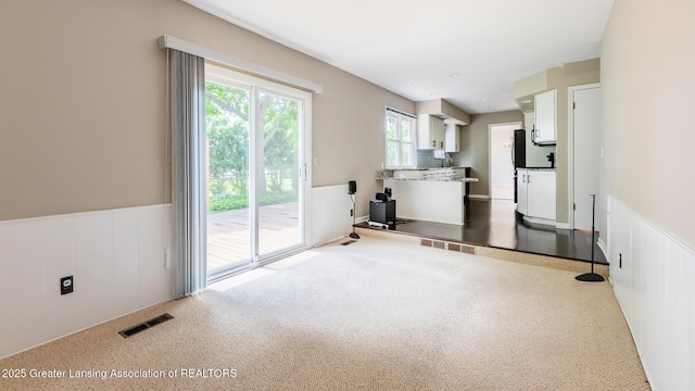 1965 Rutgers Cir, East Lansing, MI 48823 - unfurnished living room with a wainscoted wall and carpet flooring