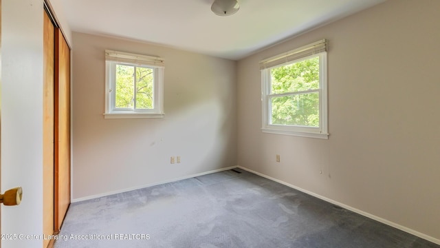 1965 Rutgers Cir, East Lansing, MI 48823 - unfurnished bedroom with multiple windows, carpet, and a closet