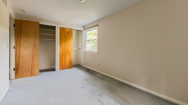 1965 Rutgers Cir, East Lansing, MI 48823 - unfurnished bedroom featuring carpet and multiple closets