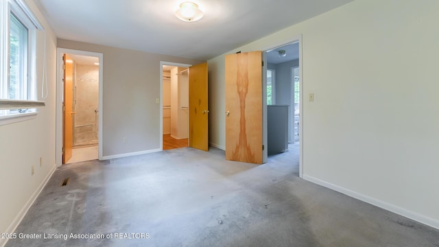 1965 Rutgers Cir, East Lansing, MI 48823 - unfurnished bedroom featuring ensuite bath, carpet flooring, and a spacious closet