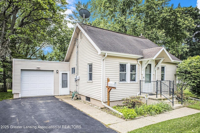 725 Center St, Mason, MI 48854 - view of front of home with a garage, a shingled roof, and asphalt driveway