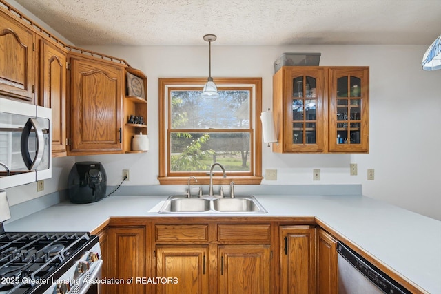 921 Ives Rd, Mason, MI 48854 - kitchen featuring stainless steel appliances, a sink, brown cabinets, pendant lighting, and light countertops