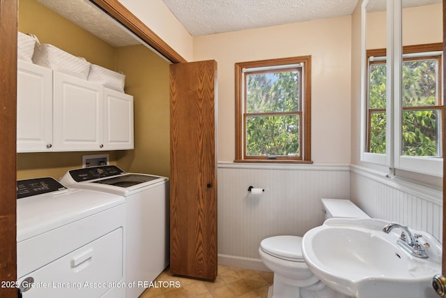 921 Ives Rd, Mason, MI 48854 - bathroom featuring a sink, wainscoting, independent washer and dryer, toilet, and a textured ceiling
