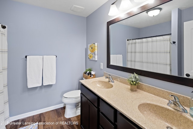 15925 Turnberry St, Lansing, MI 48906 - bathroom featuring double vanity, wood finished floors, and a shower with curtain