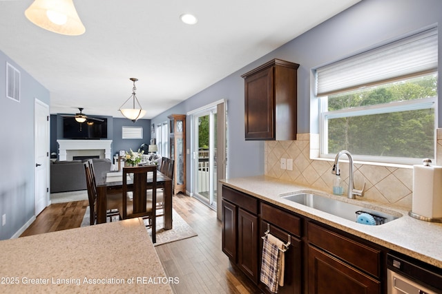 15925 Turnberry St, Lansing, MI 48906 - kitchen featuring healthy amount of natural light, wood finished floors, tasteful backsplash, pendant lighting, and recessed lighting