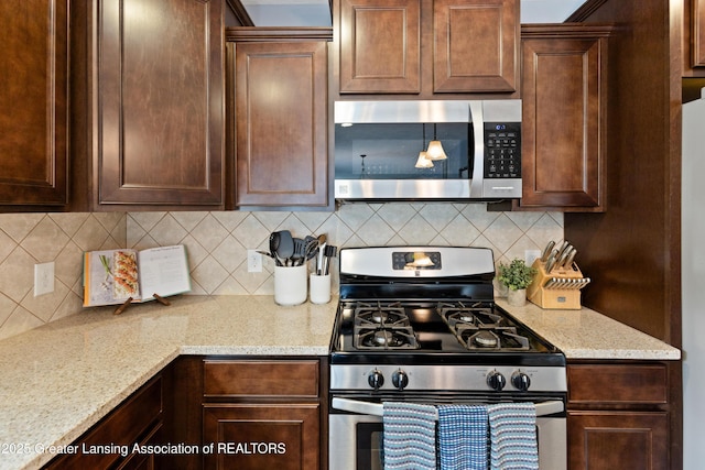15925 Turnberry St, Lansing, MI 48906 - kitchen featuring stainless steel appliances, tasteful backsplash, dark brown cabinetry, and light stone counters