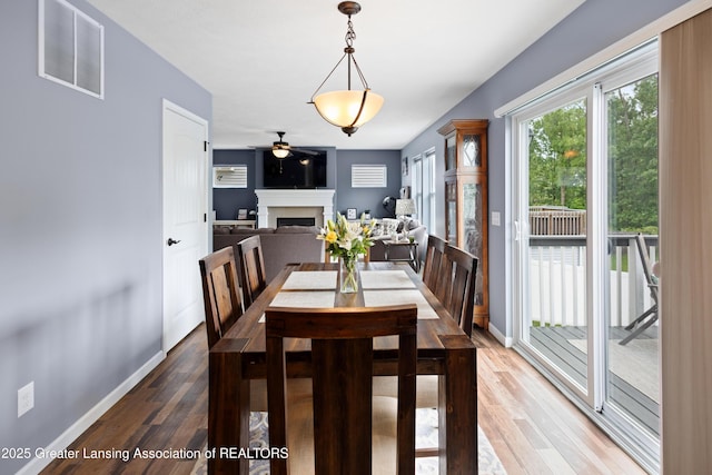 15925 Turnberry St, Lansing, MI 48906 - dining area featuring a fireplace, wood finished floors, and a ceiling fan