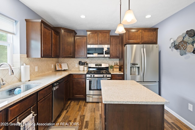 15925 Turnberry St, Lansing, MI 48906 - kitchen with stainless steel appliances, dark wood finished floors, a kitchen island, backsplash, and recessed lighting