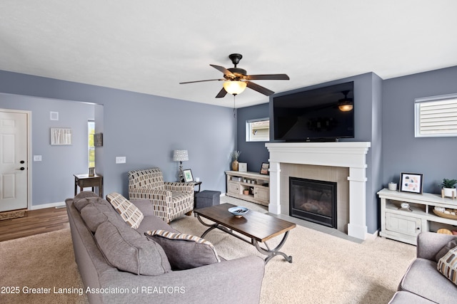 15925 Turnberry St, Lansing, MI 48906 - living room featuring ceiling fan, a fireplace with flush hearth, and carpet