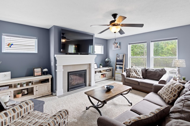 15925 Turnberry St, Lansing, MI 48906 - carpeted living room with a ceiling fan and a fireplace with flush hearth