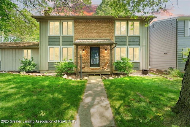 992 Touraine Ave, East Lansing, MI 48823 - view of front of home featuring a front yard, board and batten siding, and brick siding