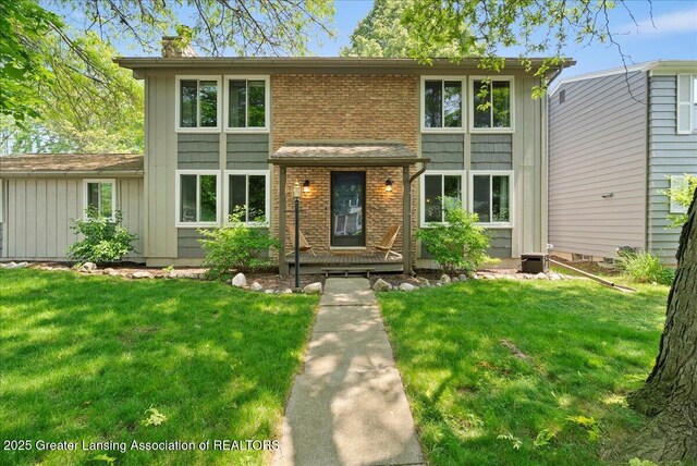 992 Touraine Ave, East Lansing, MI 48823 - view of front of property with a front lawn, board and batten siding, and brick siding