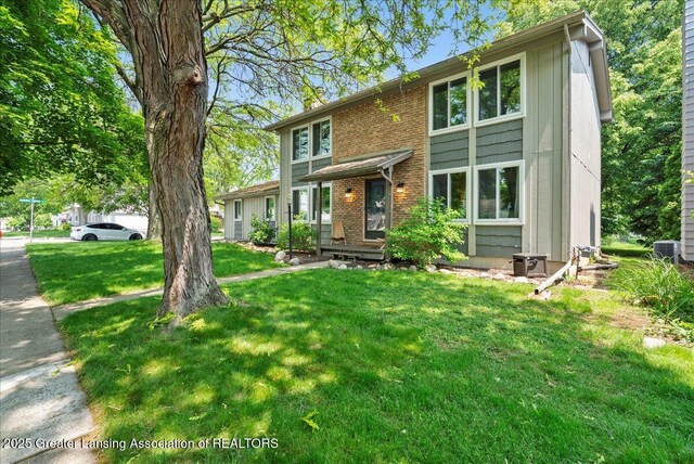 992 Touraine Ave, East Lansing, MI 48823 - view of front facade featuring a front lawn, cooling unit, and brick siding