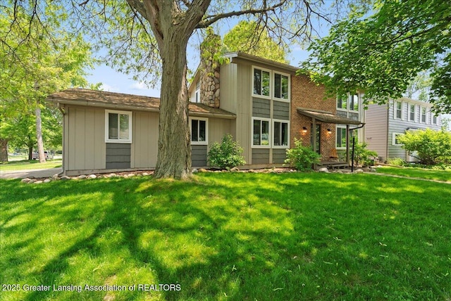 992 Touraine Ave, East Lansing, MI 48823 - rear view of property with a lawn, a chimney, and board and batten siding