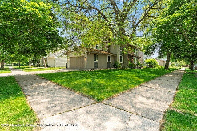 992 Touraine Ave, East Lansing, MI 48823 - view of front of home featuring driveway, an attached garage, and a front yard