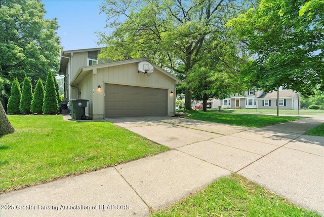 992 Touraine Ave, East Lansing, MI 48823 - view of front facade with a front yard, concrete driveway, and an attached garage