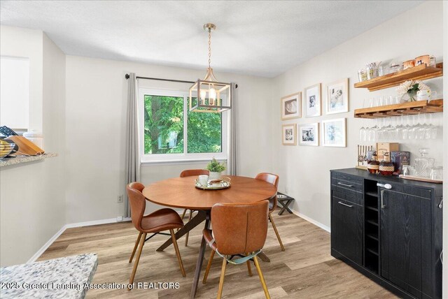 992 Touraine Ave, East Lansing, MI 48823 - dining room with a dry bar, light wood-style flooring, and baseboards