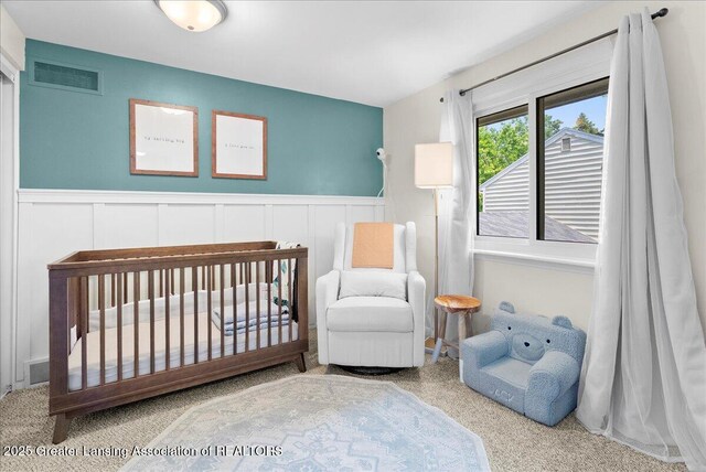 992 Touraine Ave, East Lansing, MI 48823 - bedroom featuring a wainscoted wall, a decorative wall, and a nursery area