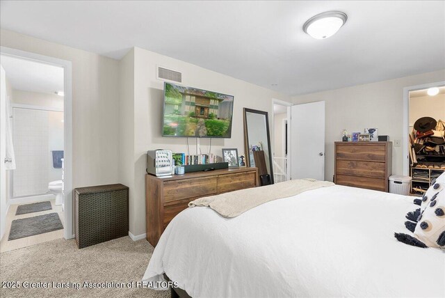 992 Touraine Ave, East Lansing, MI 48823 - bedroom with light carpet, ensuite bathroom, and baseboards