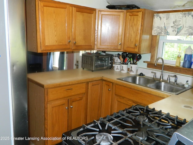 161 Okemos Rd, Mason, MI 48854 - kitchen with a sink, light countertops, brown cabinets, and stove