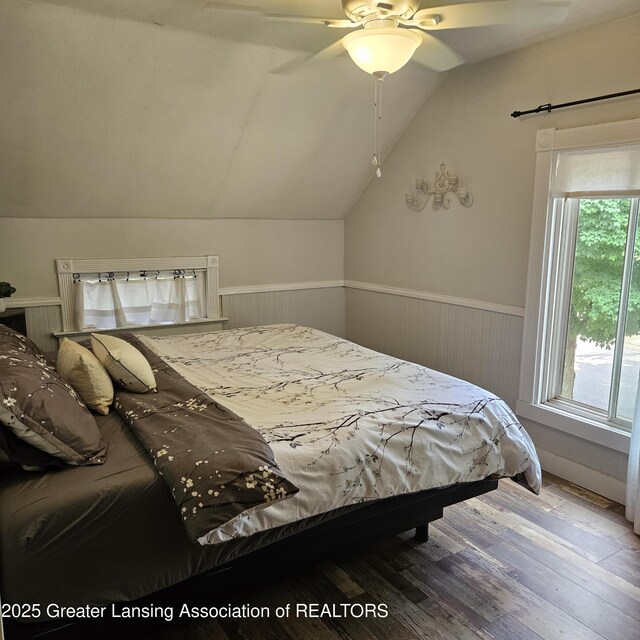 405 E Shaw St, Charlotte, MI 48813 - bedroom featuring vaulted ceiling, wainscoting, wood finished floors, and a ceiling fan