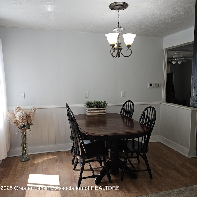 405 E Shaw St, Charlotte, MI 48813 - dining space featuring wood finished floors, wainscoting, a chandelier, a textured ceiling, and ceiling fan