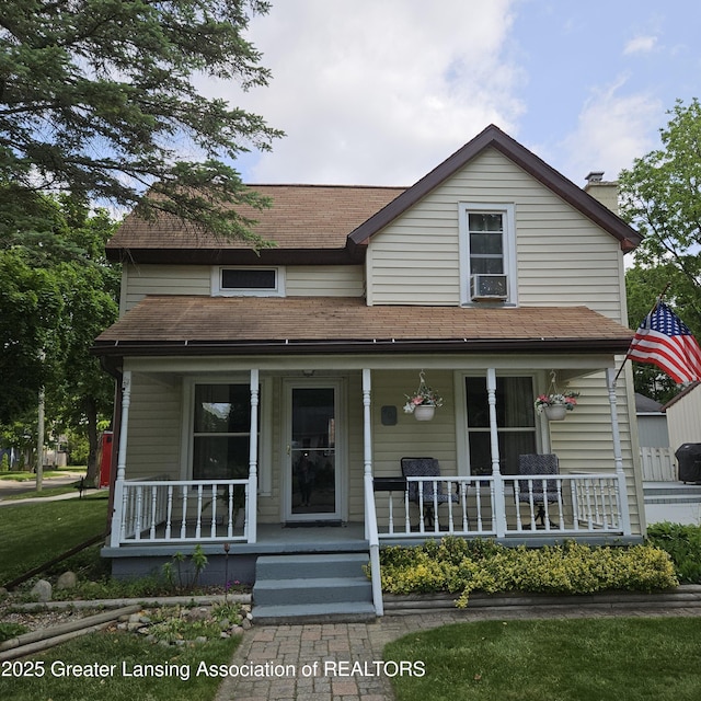 405 E Shaw St, Charlotte, MI 48813 - view of front of home featuring a porch, a chimney, and a shingled roof
