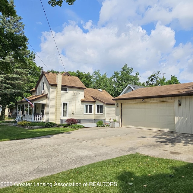 405 E Shaw St, Charlotte, MI 48813 - view of front of home with a garage, covered porch, and a front lawn