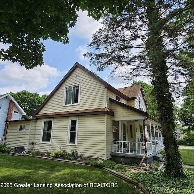 405 E Shaw St, Charlotte, MI 48813 - view of home's exterior featuring a porch, a yard, and central air condition unit