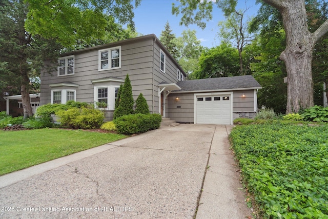 932 Sunset Ln, East Lansing, MI 48823 - view of front facade featuring driveway, an attached garage, and a front yard