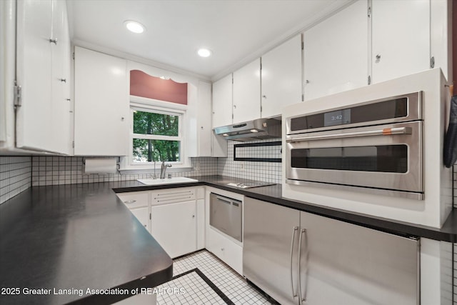 932 Sunset Ln, East Lansing, MI 48823 - kitchen with stainless steel oven, white cabinets, backsplash, and recessed lighting