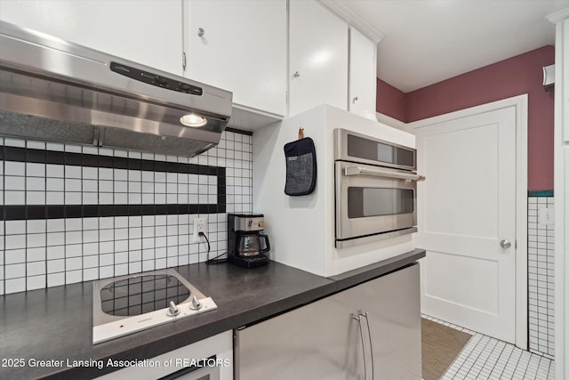 932 Sunset Ln, East Lansing, MI 48823 - kitchen featuring range hood, white cabinets, tasteful backsplash, and dark countertops
