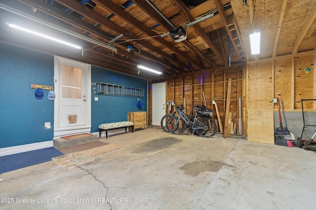 932 Sunset Ln, East Lansing, MI 48823 - garage featuring a garage door opener and baseboards