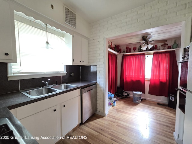812 Westmoreland Ave, Lansing, MI 48915 - kitchen featuring stainless steel dishwasher, a sink, dark countertops, white cabinetry, and ceiling fan