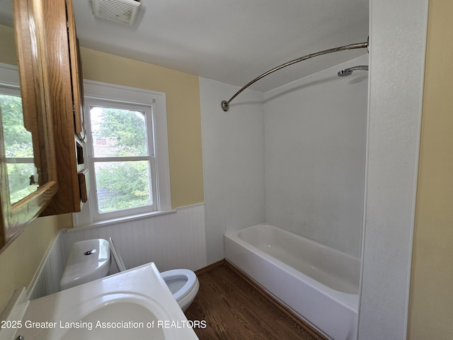 812 Westmoreland Ave, Lansing, MI 48915 - bathroom with a wainscoted wall, toilet, wood finished floors, and shower / bath combination